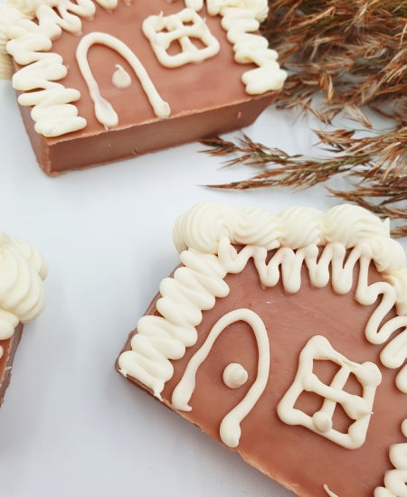 Handgemachte Seifenstücke in Form von Lebkuchenhäusern auf weißem Hintergrund mit Schilfgras Nahaufnahme